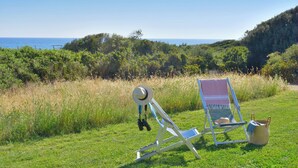 A beach chair and a hat on a grassy field with a view of the sea and hills. - Dune (Montalto di Castro)