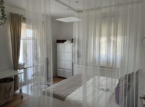 Ein Schlafzimmer mit einem Bett, einem Kleiderschrank und einem Schreibtisch.