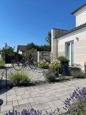 A paved courtyard with a bicycle, a gate, and a building with a door.