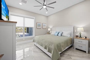A bedroom with a bed, bedside tables, a ceiling fan, and a window with a view. - Wonderful 4-bedroom house with AC in tranquil Cape Coral (Cape Coral)