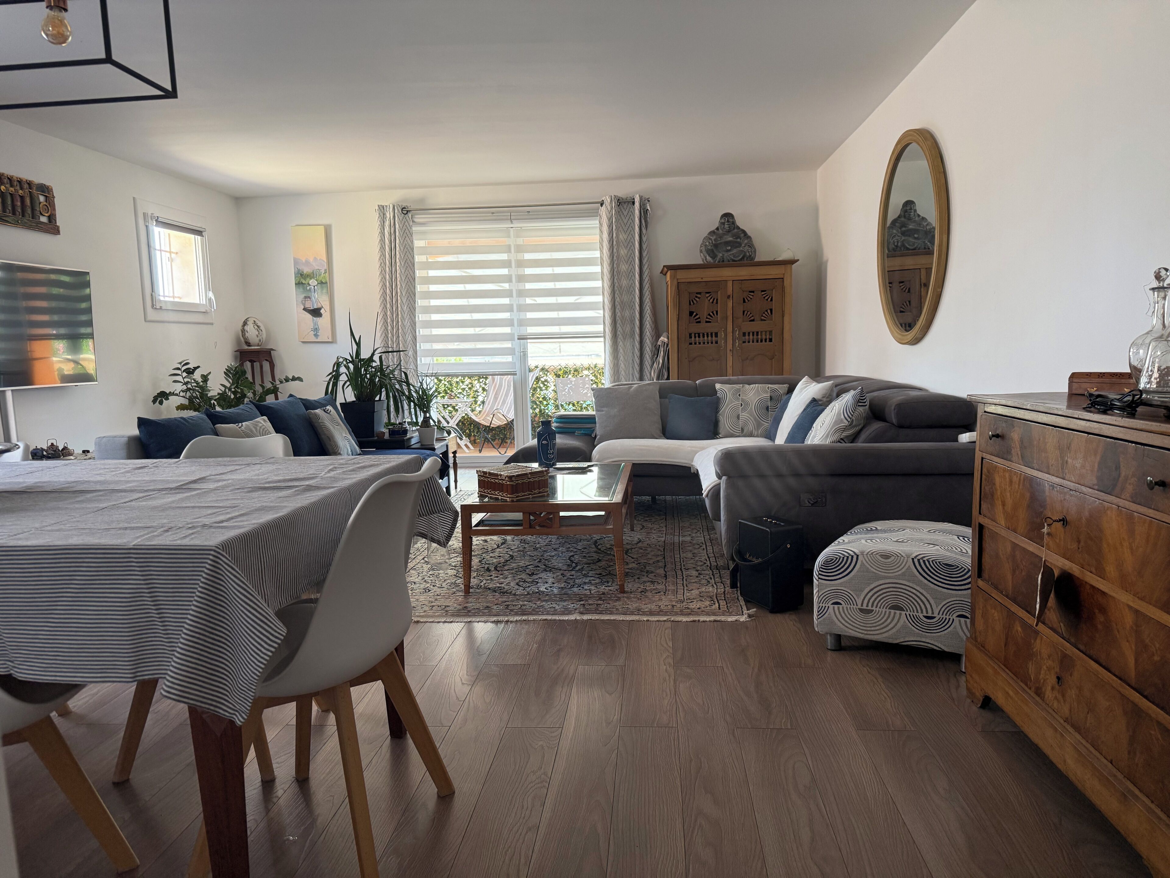A modern living room with a sofa, coffee table, and dining area.