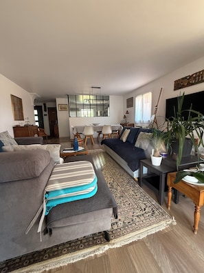 A living room with a sofa, ottoman, coffee table, and a television. - Villa (90-square-meter home) (Fréjus)