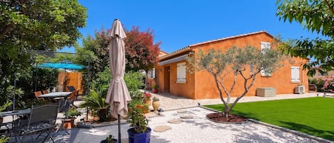 A patio area with outdoor furniture, a pergola, and a small tree.