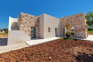 A modern building with a stone facade, a staircase, and a landscaped garden. - Onirica Dimora by BarbarHouse (Salve)