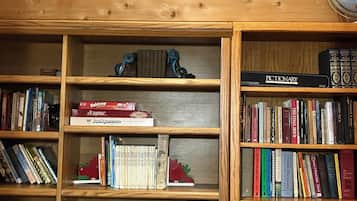 Une étagère en bois remplie de livres, avec une pancarte au-dessus indiquant : « ARCHANGEL TRAIL ».