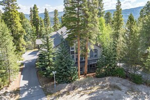 A two-story house surrounded by tall pine trees with a driveway leading to the entrance. - Gold King House: Hot Tub, Pool Table. Near Peak 10 (Breckenridge)
