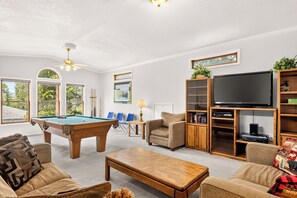 A living room with a pool table, comfortable seating, a television, and a bookshelf. - Gold King House: Hot Tub, Pool Table. Near Peak 10 (Breckenridge)