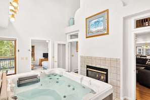 A modern bathroom with a bathtub, a fireplace, and a painting on the wall. - Gold King House: Hot Tub, Pool Table. Near Peak 10 (Breckenridge)