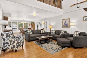 Un ampio soggiorno con un divano componibile, una poltrona decorata e un tavolino da caffè.