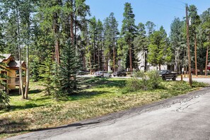 A residential area with a wooden cabin, a paved road, and several vehicles parked along the street. - NEW - Charming 2-Bedroom Condo Near Shuttle Stops and Downtown (Breckenridge)