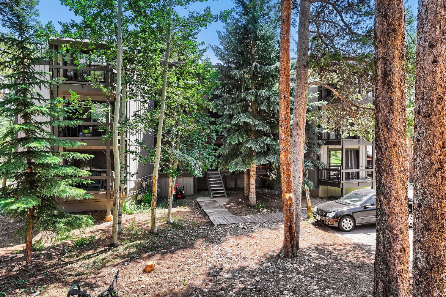 A multi-story building with a covered outdoor area, surrounded by trees.