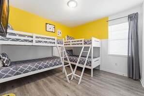 A room with bunk beds, a ladder, a window with curtains, and a wall clock. - House 12Q with Pool with Heating - and Game Room (Kissimmee)