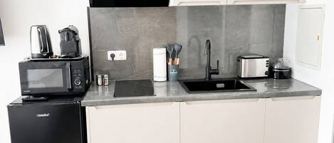 A modern kitchen with a built-in microwave, toaster, and coffee maker.