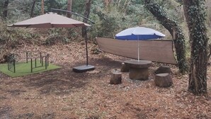 Un espacio al aire libre con pérgola, una mesa y un banco.