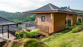 A traditional wooden building with a tiled roof, a small window, and a balcony with a railing.