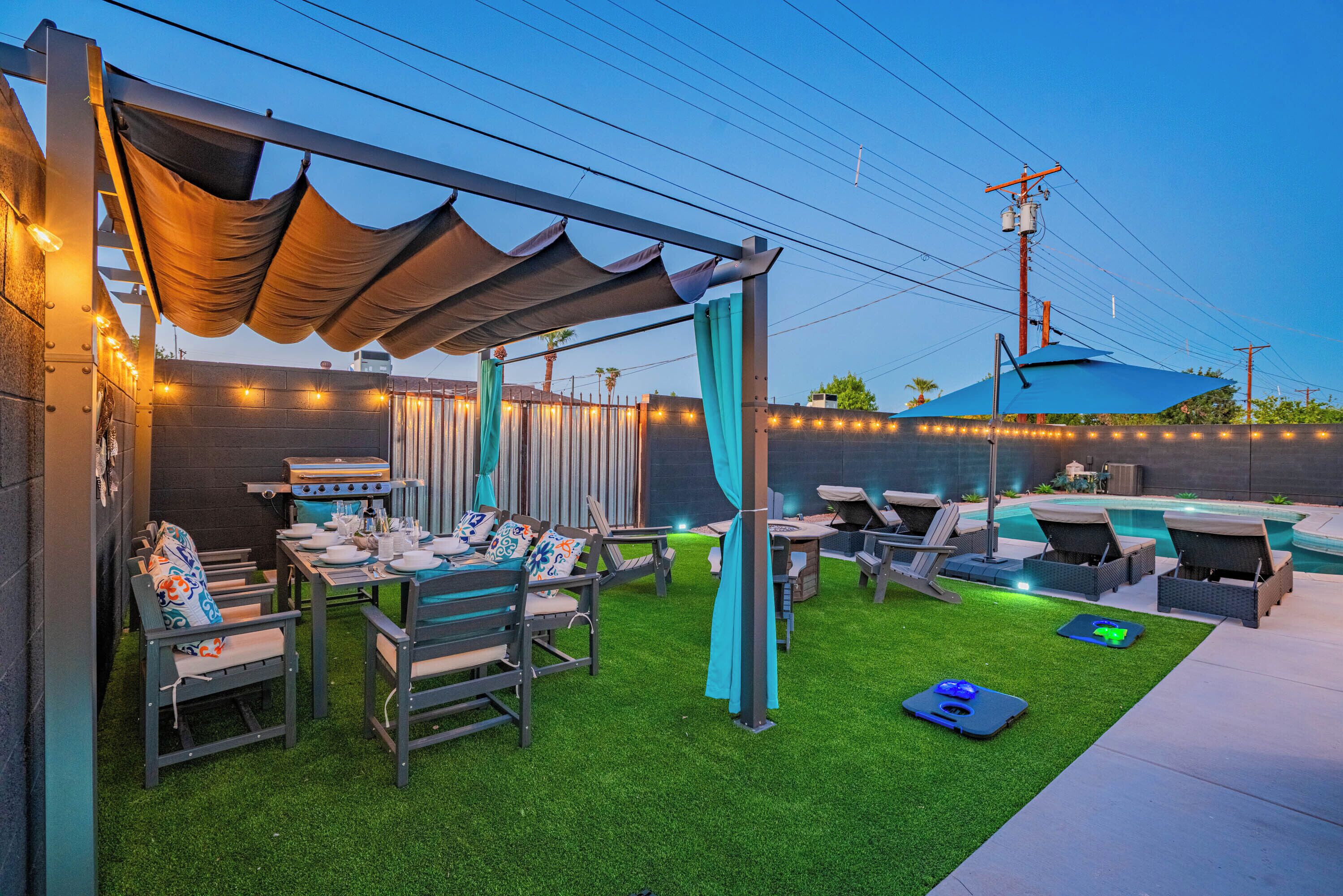 A backyard with a barbecue area, outdoor seating, and a swimming pool.