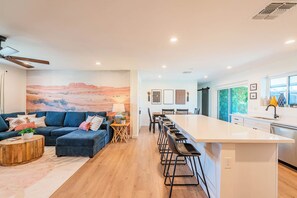 Un salon moderne avec un canapé, une table basse et un tableau accroché au mur.