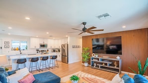 Un espacio habitable moderno con cocina, comedor y zona de entretenimiento.
