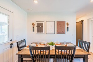 A dining room with a wooden table, four chairs, and three framed artworks on the wall. - Spacious 5-bedroom house in lovely Scottsdale with AC (Scottsdale)