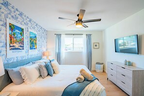 A bedroom with a bed, a ceiling fan, a TV, and artwork on the wall. - Spacious 5-bedroom house in lovely Scottsdale with AC (Scottsdale)