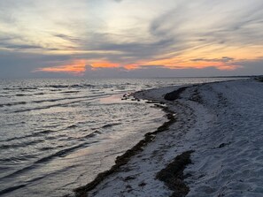Una playa con vista al océano y un atardecer.