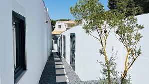 A narrow alleyway with white walls, a tiled roof, and a small tree. - Sun, sea, and Lisbon—your vacation home is waiting for you (Costa de Caparica)