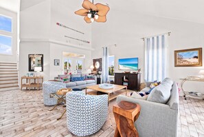 Ein geräumiges Wohnzimmer mit einer großen Couch, einem Couchtisch und gemusterten Hocker.