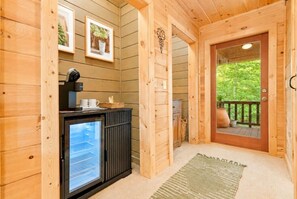 Un intérieur en bois avec un réfrigérateur, une machine à café et des tableaux encadrés accrochés au mur.