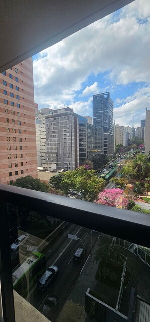 A cityscape with modern buildings, a clear sky, and a street with cars and greenery. - On Lorena (São Paulo)
