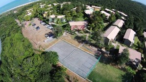 An aerial view of a residential area with houses, a parking lot, and a large open space.