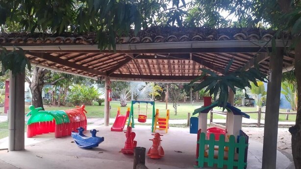 A children's play area with various play structures and a covered seating area.