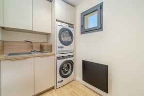 A compact laundry room with a washing machine, a dryer, and a small window. - Villa Eméa |Pool, gym & pétanque court (Le Puy-Sainte-Réparade)