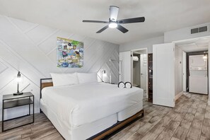 A hotel room with a bed, a ceiling fan, a nightstand, a wall art piece, and an open closet. - Modern King Condo Pool and Minutes to Old Town 208 (Scottsdale)