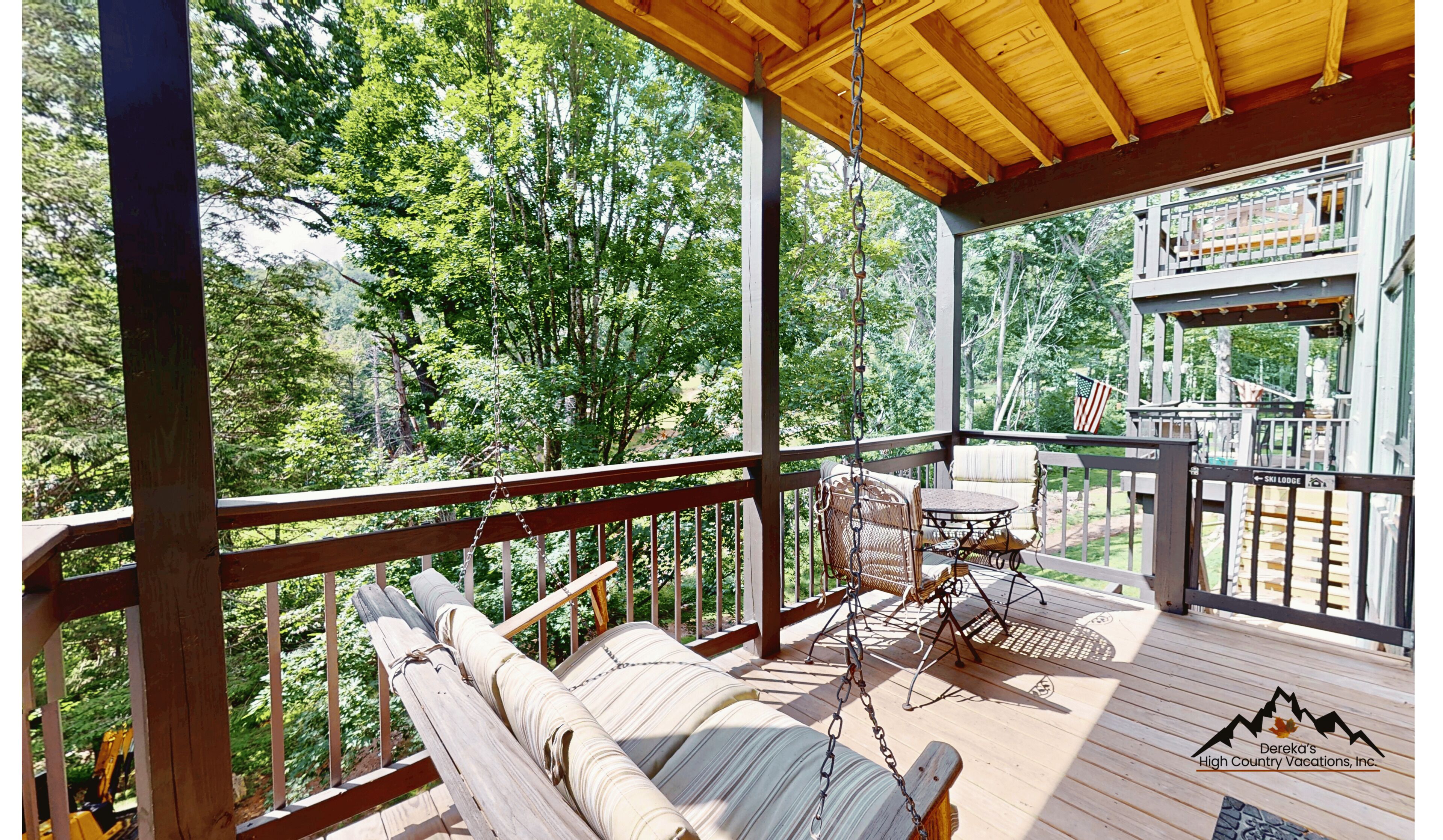 A covered balcony overlooks lush greenery, with a swing offering the perfect spot to unwind while surrounded by peaceful mountain trees and fresh air.