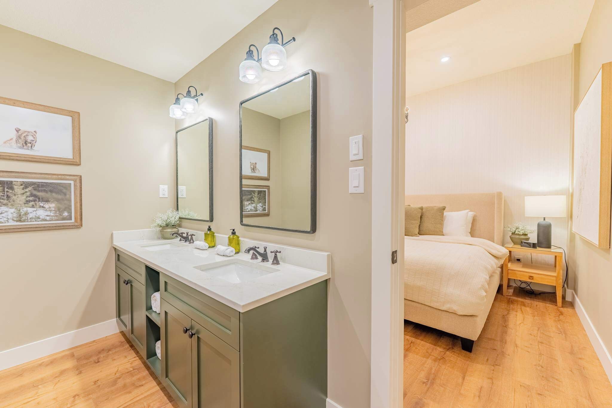 A modern bathroom with a double sink vanity, a large mirror, and wall-mounted lights.