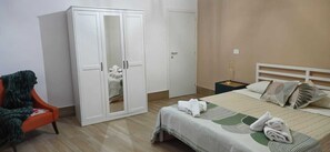 A bedroom with a bed, a wardrobe, a chair, and a nightstand. - Sambè Apartment—Your Stay in the Heart of Catania (Catania)