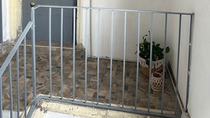 Ein Flur mit einer grauen Tür, einem Willkommensschild und einem Gemälde eines Fahrrads.