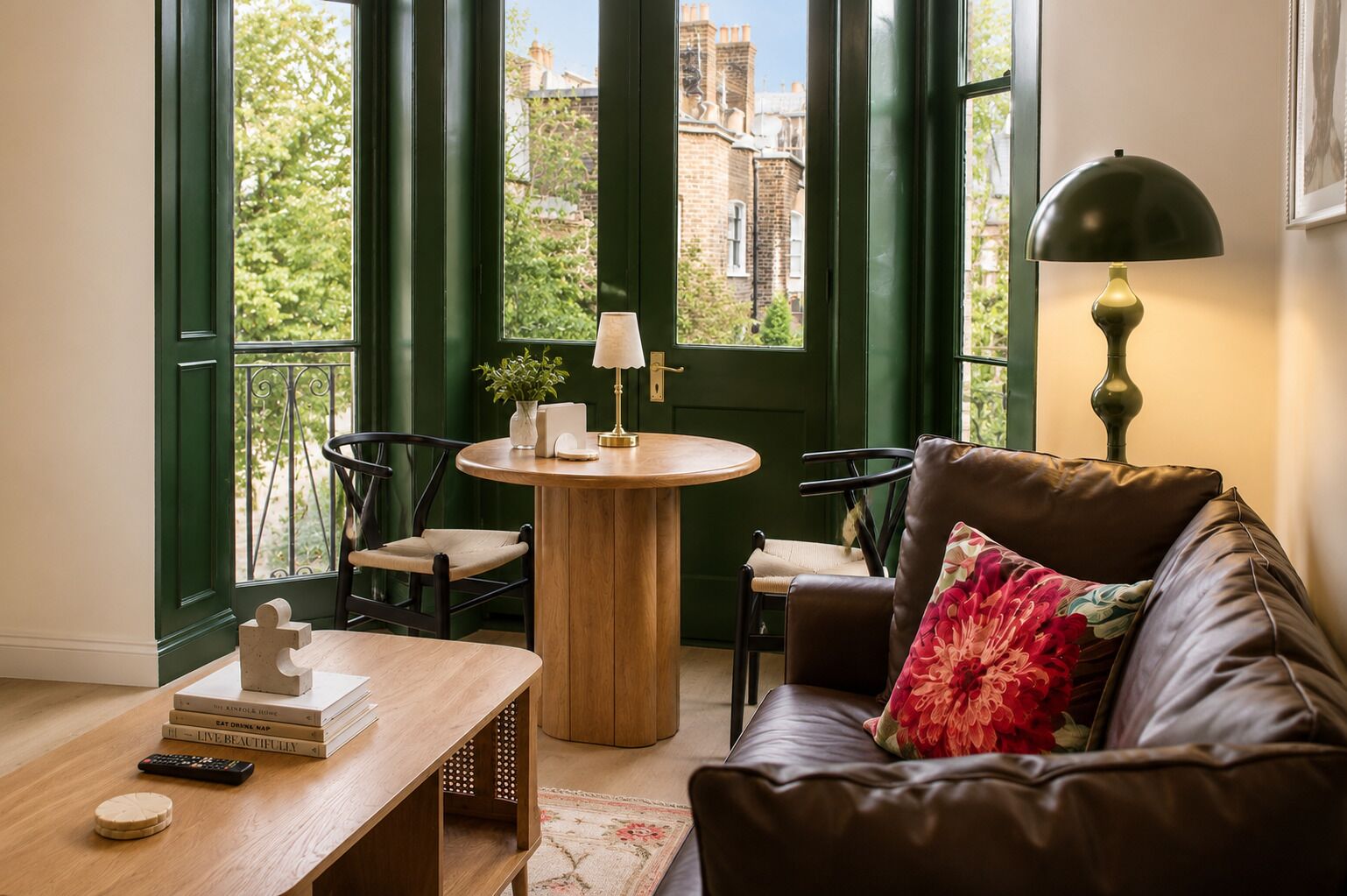 A cozy living room with a leather sofa, a wooden coffee table, and a round table with chairs.