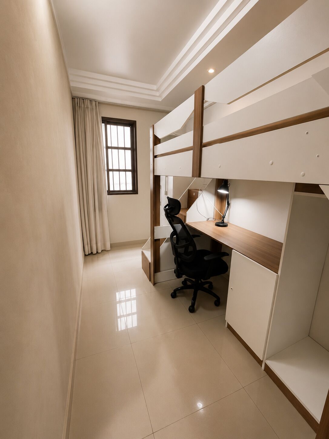 A bedroom with a bunk bed, a desk with a chair, and a lamp.
