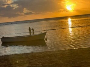 A boat on calm water during sunset. -  A  traditional, tropical Mauritian villa, 3-4 mins walk  to an amazing beach. (Balaclava)