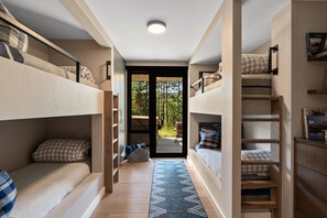 A compact room with bunk beds, a small seating area, and a view of the outdoors. - Designer home with amazing views and ski in/out.  Moonlight Basin Chalet. (Big Sky)