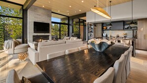 Un intérieur moderne avec une grande table à manger, des canapés et une cheminée.
