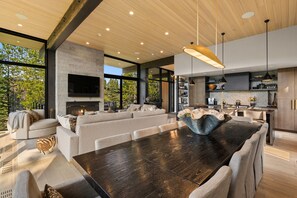 Un intérieur moderne avec une grande table à manger, des canapés et une cheminée.