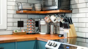 Eine Küche mit Mikrowelle, Kaffeemaschine und verschiedenen Küchengeräten.