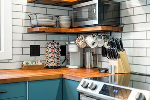 Eine Küche mit Mikrowelle, Kaffeemaschine und verschiedenen Küchengeräten.