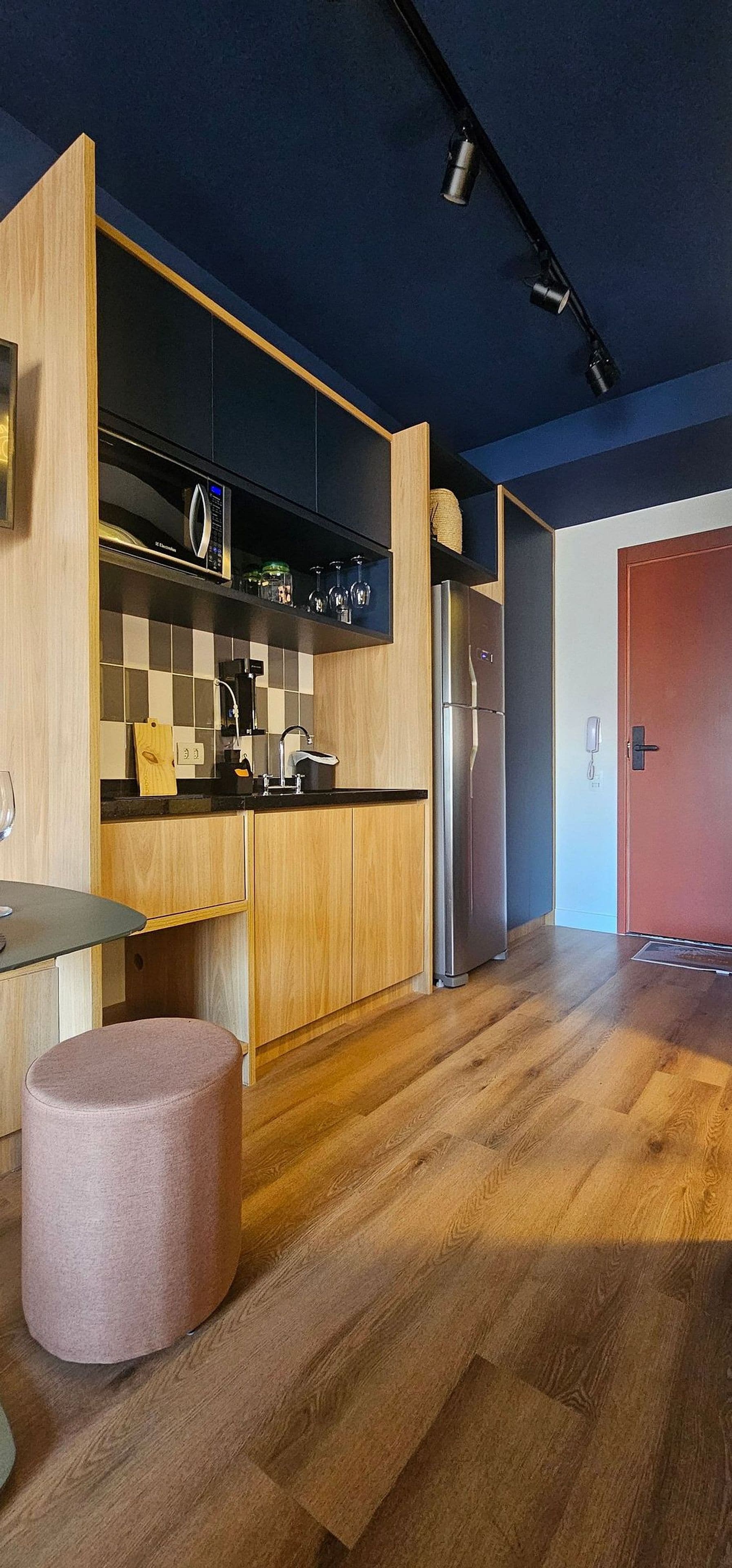 Eine moderne Küche mit Holzschränken, einem Edelstahlkühlschrank und einem eingebauten Backofen.