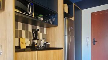 A modern kitchen with wooden cabinets, a stainless steel refrigerator, and a built-in oven.