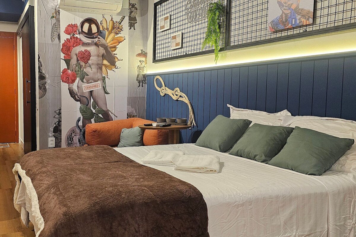 A modern bedroom with a bed, bedside table, and a wall-mounted TV.