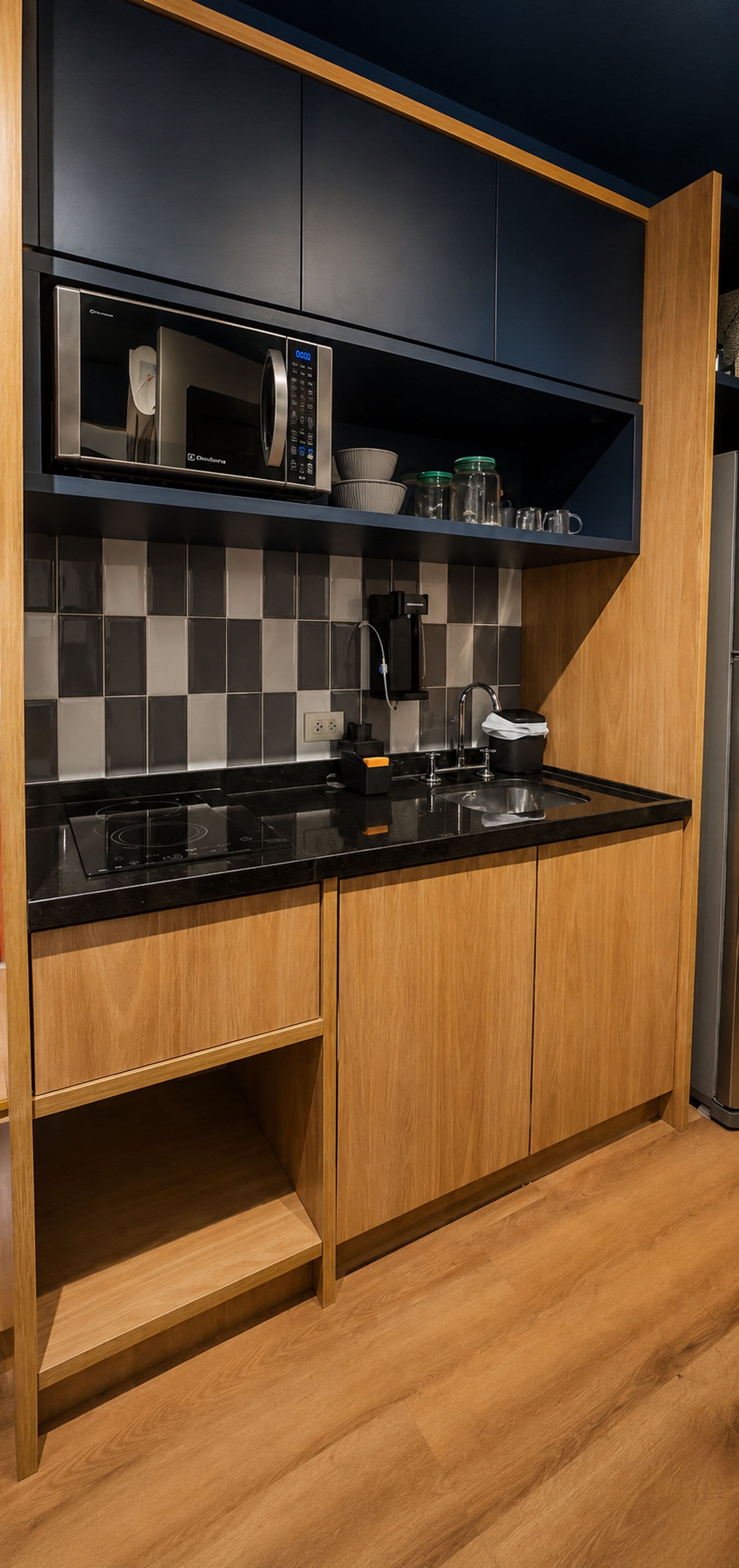 A modern kitchen with a microwave, coffee maker, and a sink.