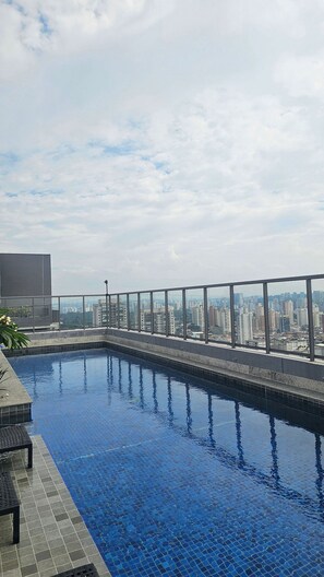 A rooftop swimming pool with a cityscape view. - Condominio Hub Brooklin (São Paulo)